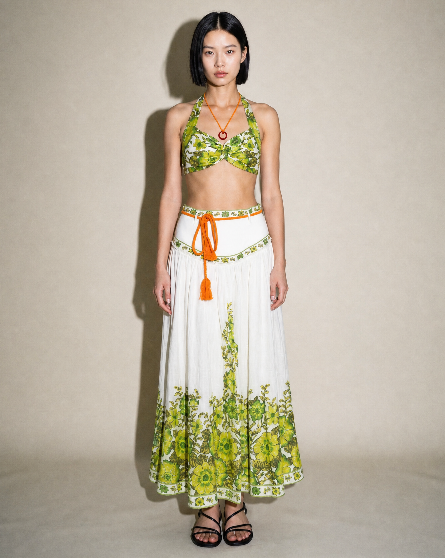 Front view of the Alémais Wallis linen set featuring a twisted halter bralette and high-waisted A-line skirt in a green botanical print.