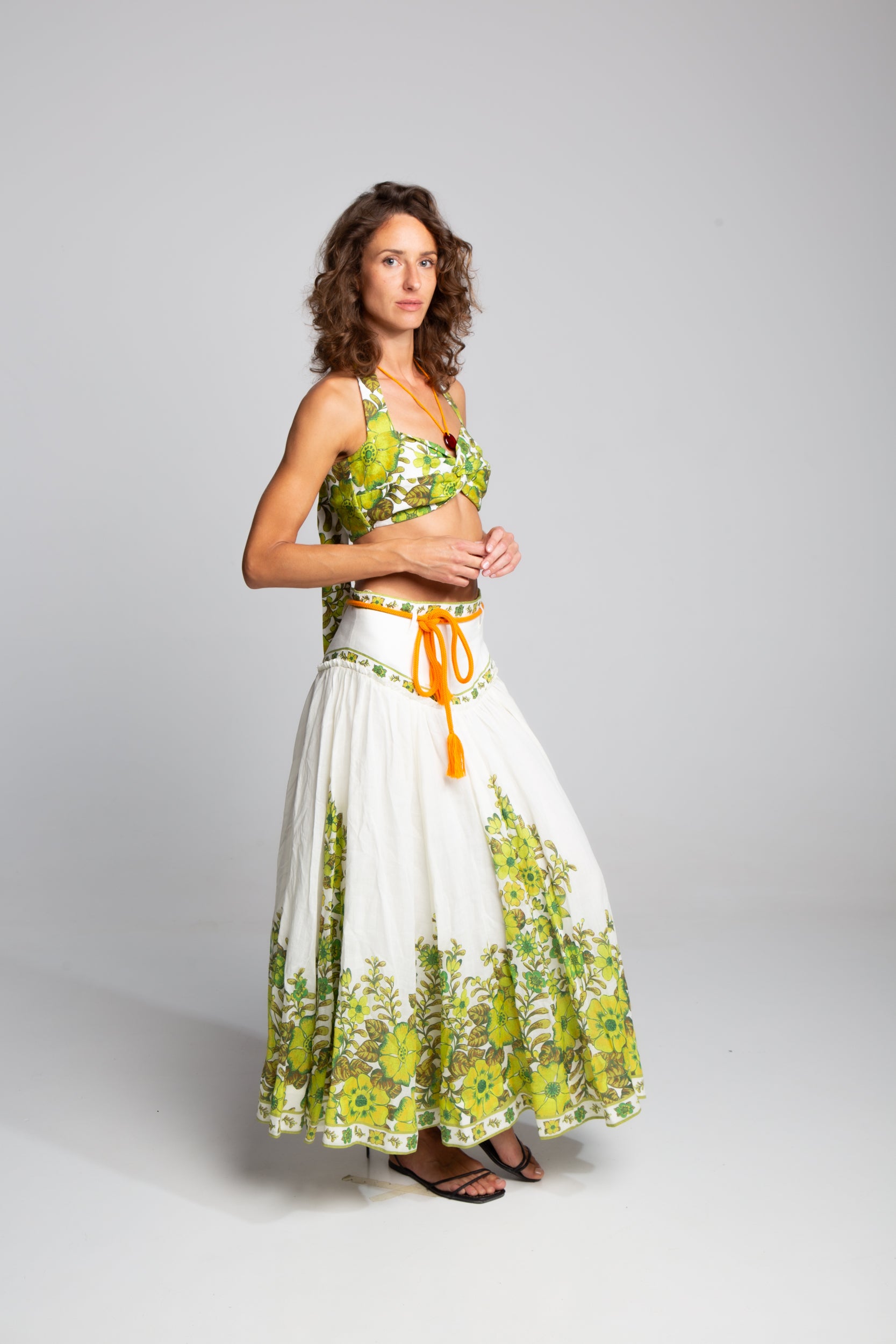 Side profile of the Alémais Wallis linen set showcasing the twisted halter top silhouette and the elegant drape of the high-waisted linen skirt.