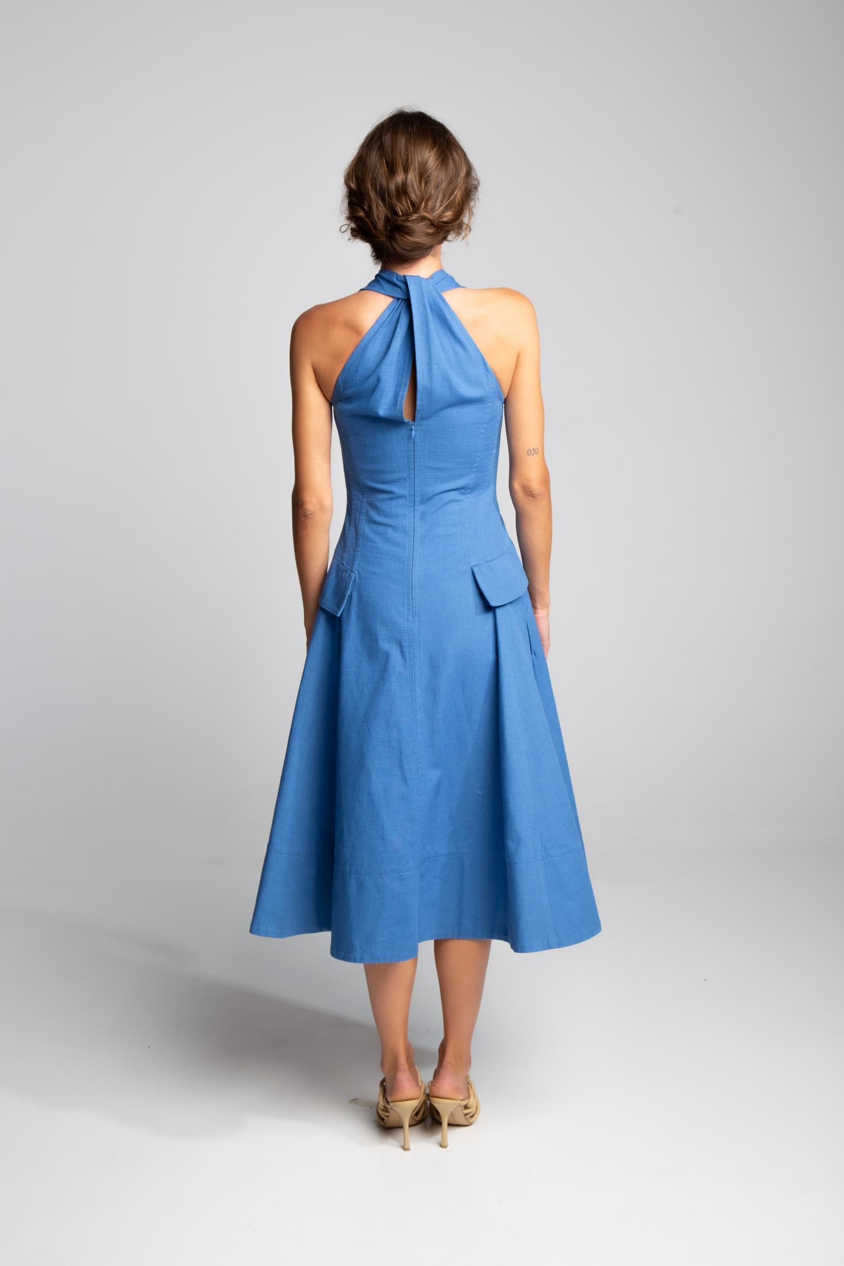 Designer halter dress with flared skirt and architectural pocket details