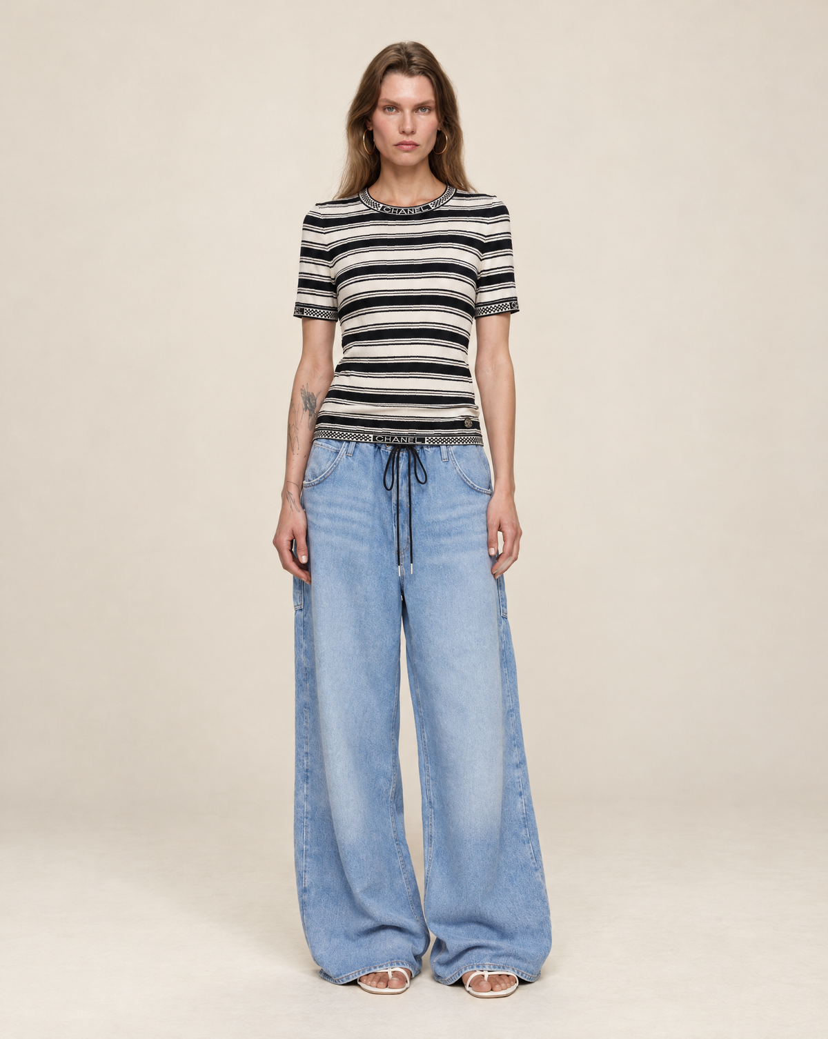 Shop this documented Chanel Cruise 2019/20 runway knit at Mezzanotte Vintage. Designed by Virginie Viard for her first solo collection, the top features black-and-white ribbed stripes and CHANEL logo trim.