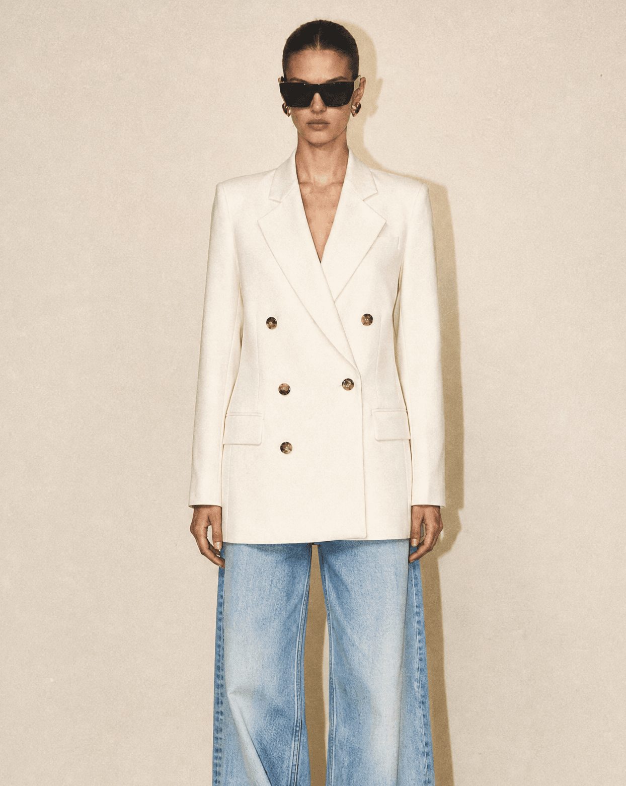 Front view of the FRAME Relaxed Double-Breasted Blazer in ivory, featuring a six-button closure and modern longline silhouette.