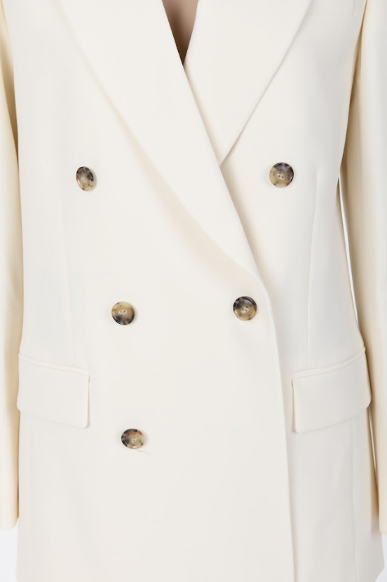 Close-up of the FRAME Relaxed Double-Breasted Blazer highlighting the notched lapels and contrasting tortoise-style buttons.