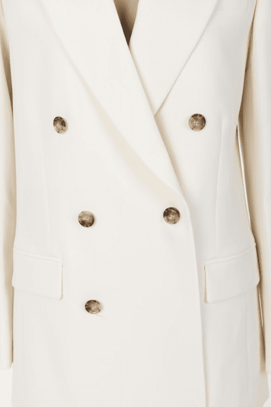 Close-up of the FRAME Relaxed Double-Breasted Blazer highlighting the notched lapels and contrasting tortoise-style buttons.