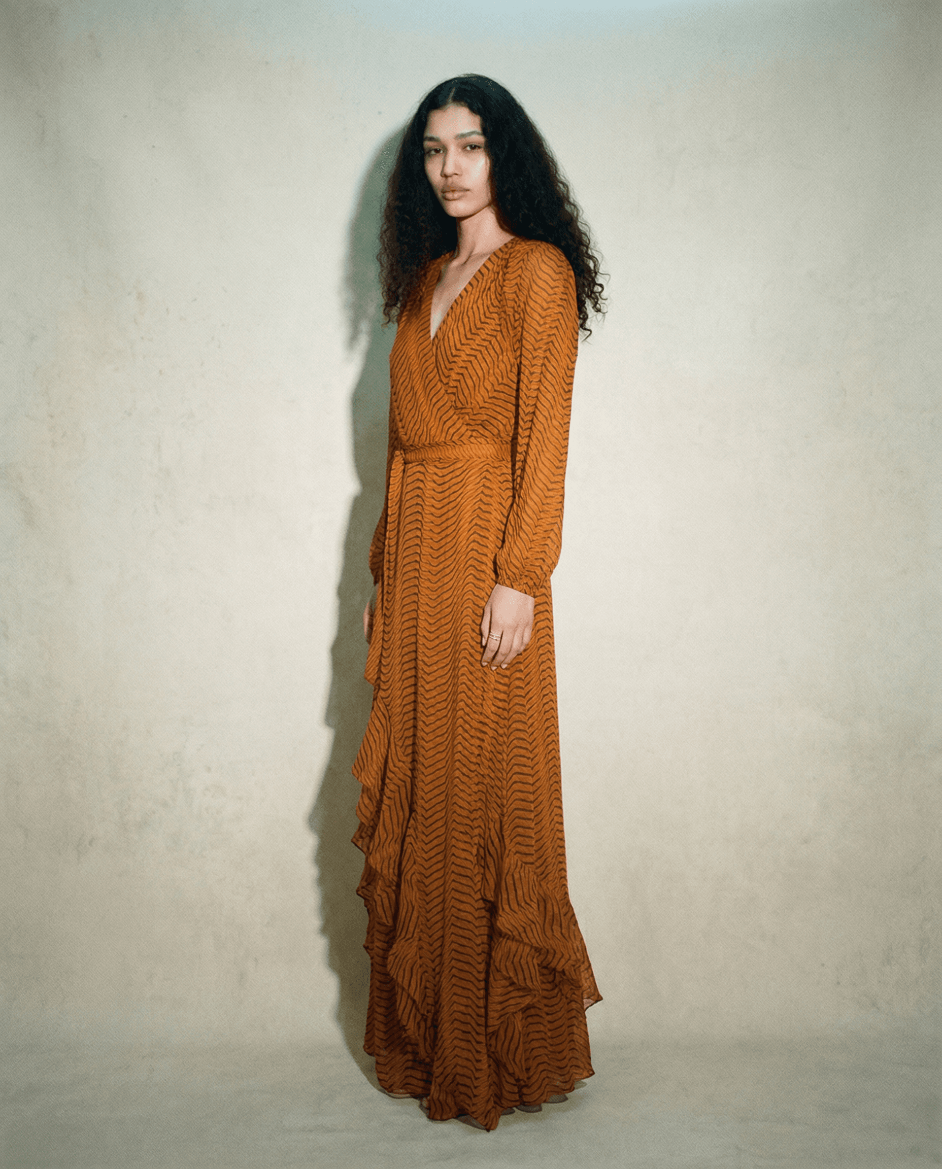 Orange silk wrap dress with flowing silhouette and long sleeves