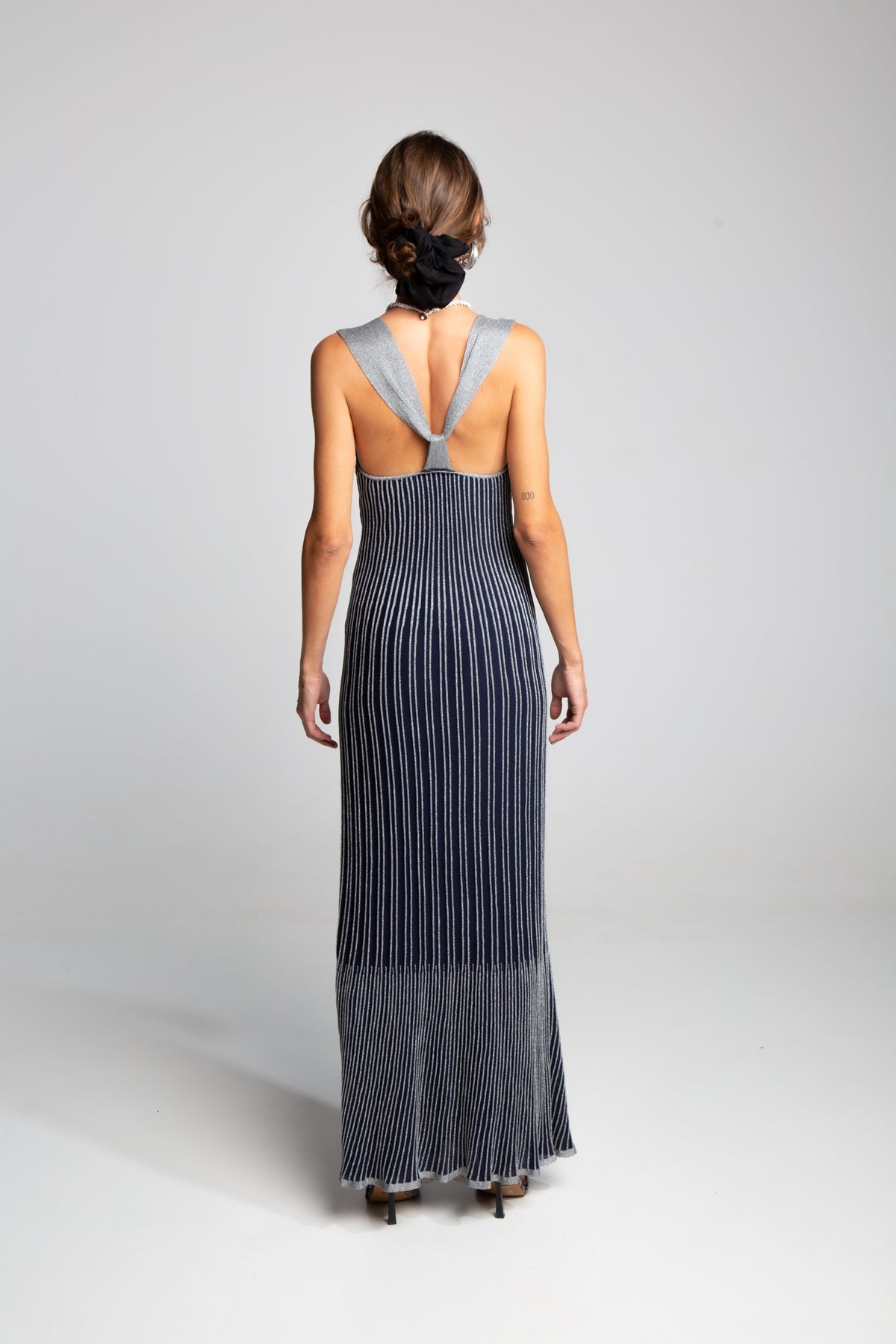 Designer knit maxi dress with deep neckline and sleek silhouette