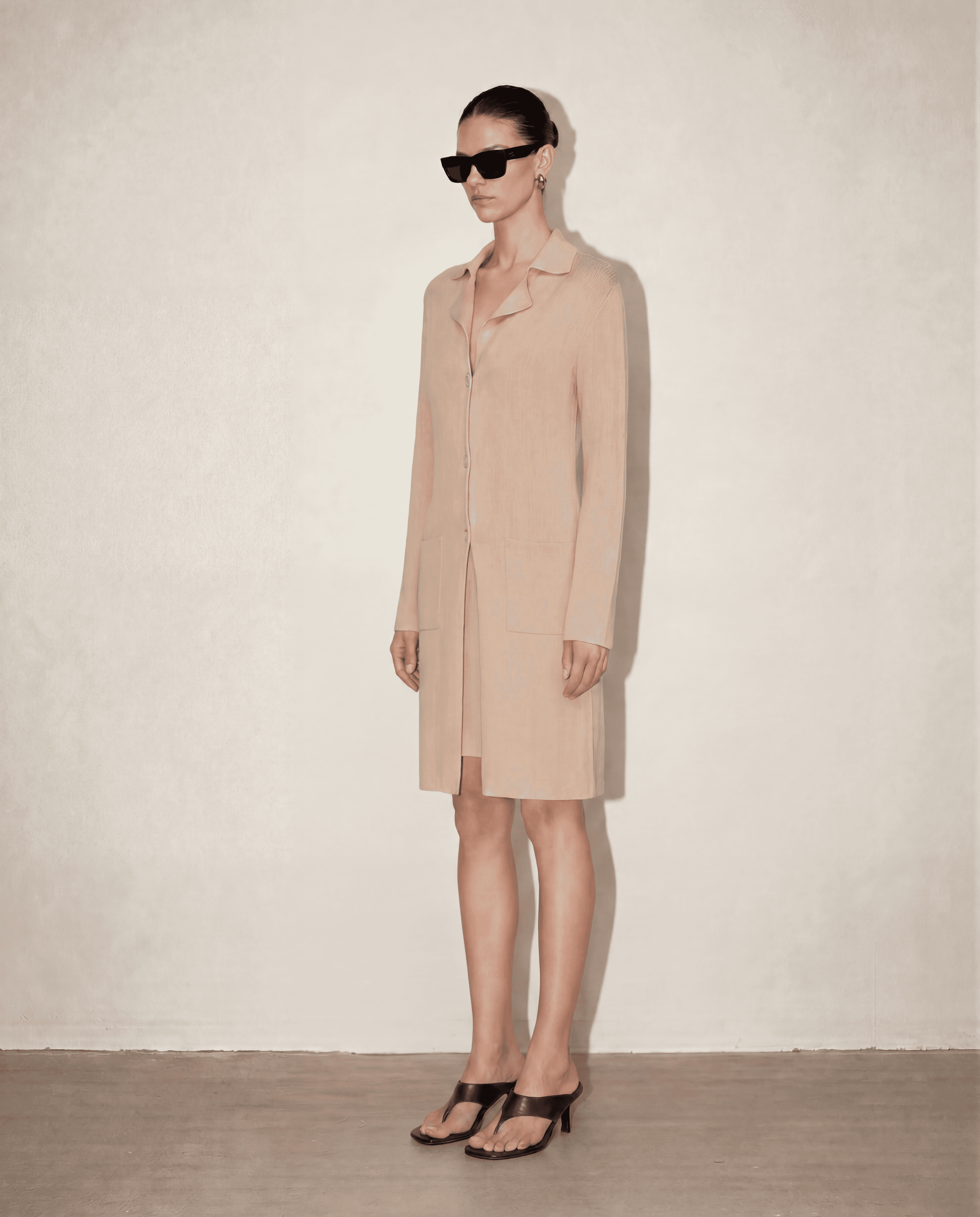 Side profile of the Malo knit set showing the body-skimming silhouette of the dress paired with the elegant drape of the longline cardigan.