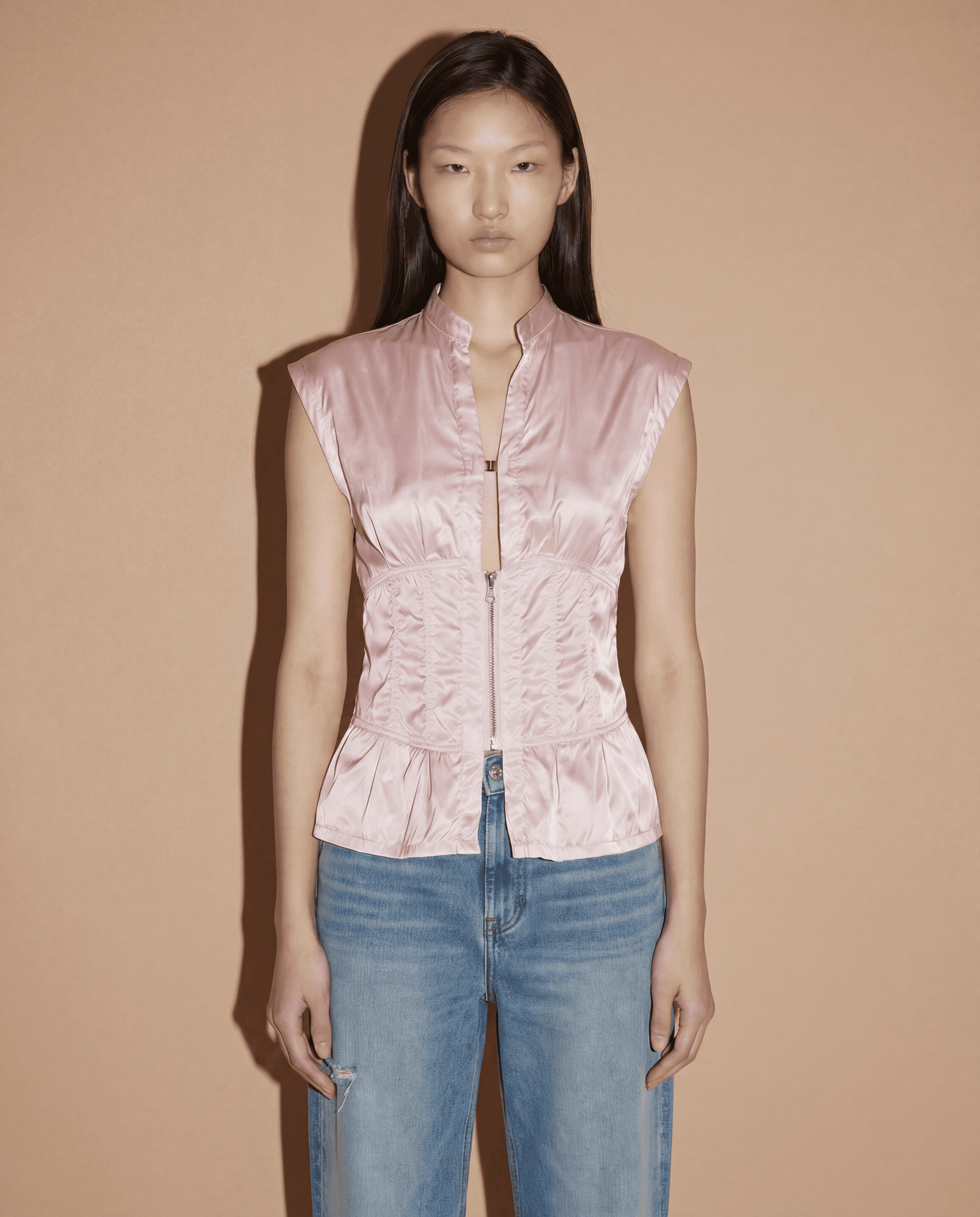 Front view of the Prada Sport corset-style top in blush pink featuring a structured zip closure and minimalist 90s silhouette.
