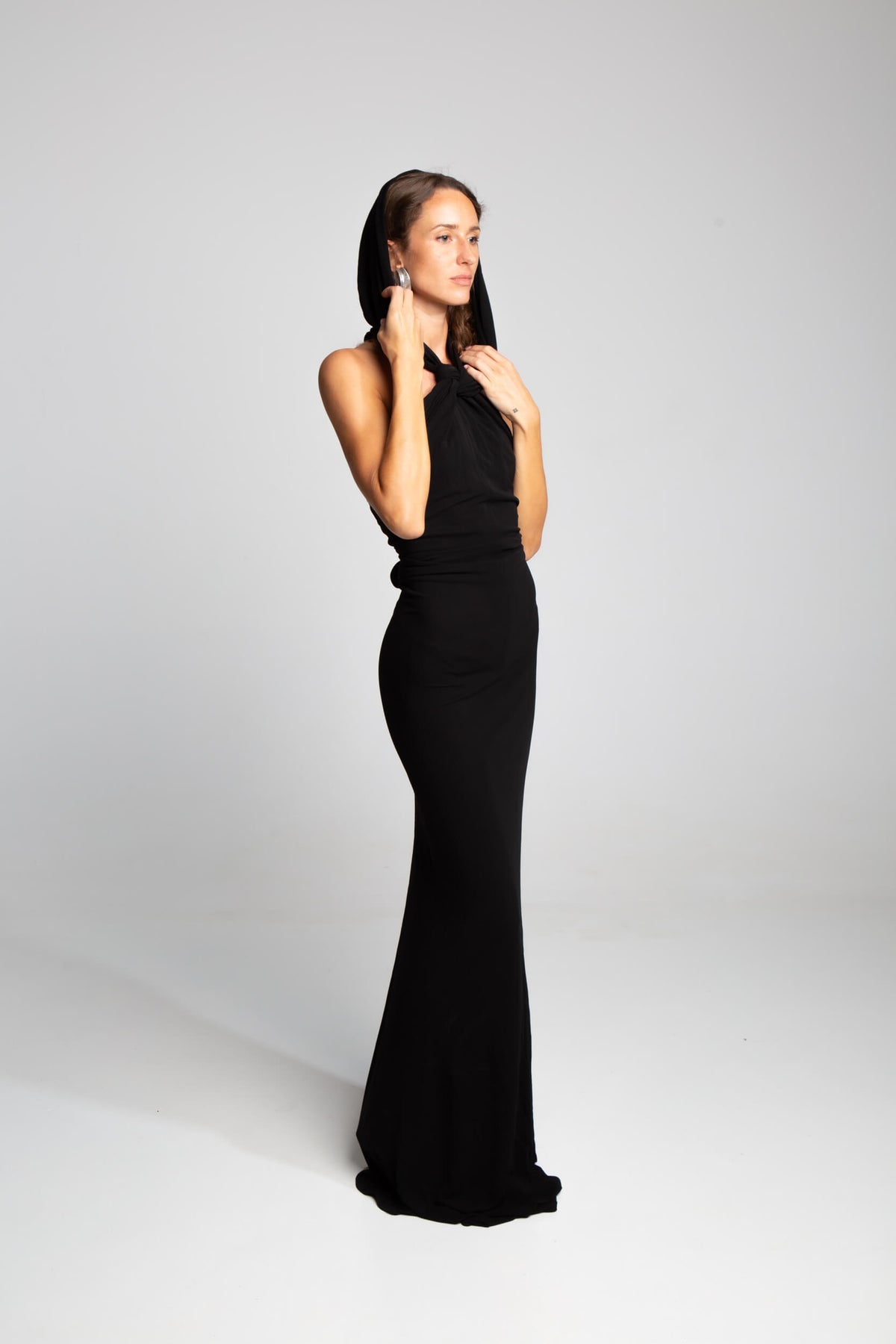 Black capuche dress with draped hood and sleek column shape Saint Laurent design