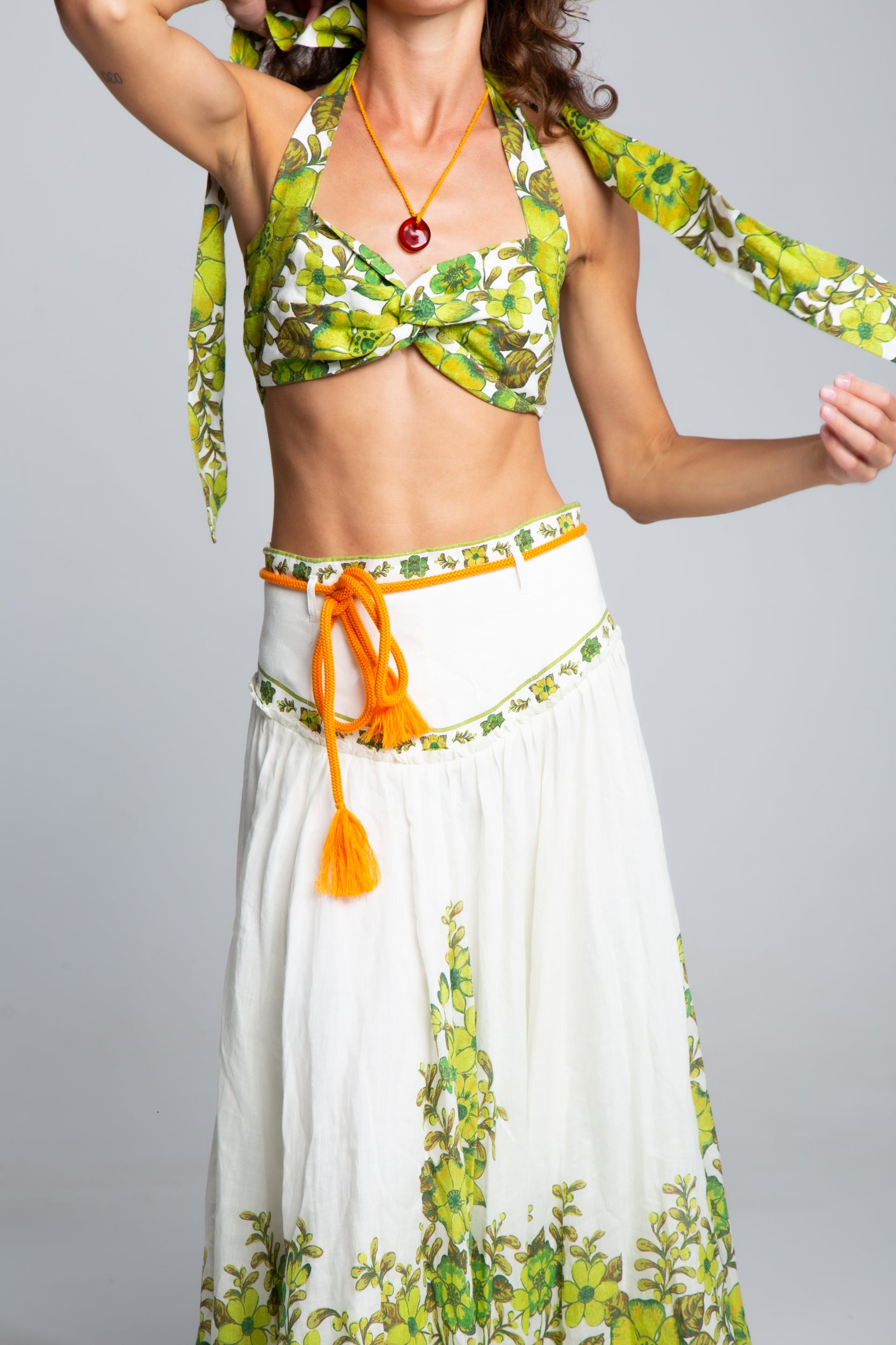 Close-up of the Alémais Wallis linen set showing the corset-style waistband with orange rope ties and decorative tassel details.