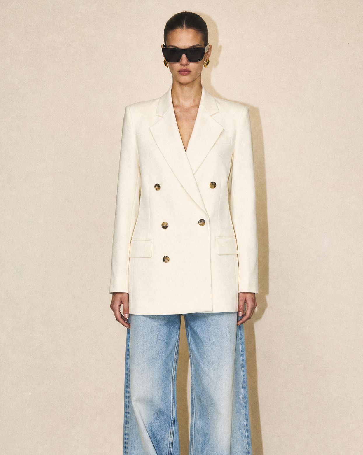 Front view of the FRAME Relaxed Double-Breasted Blazer in ivory, featuring a six-button closure and modern longline silhouette.