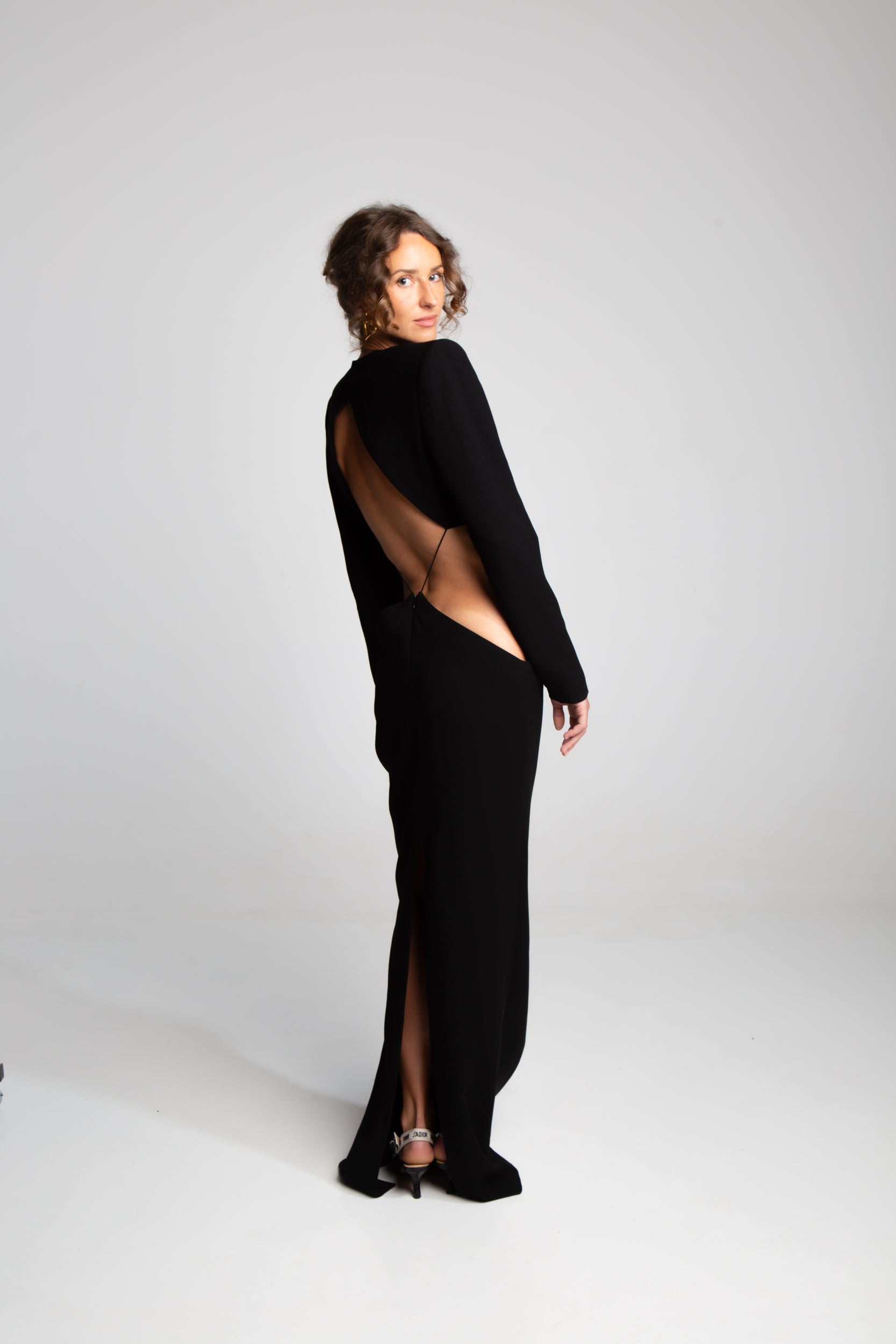 Designer black dress with architectural cut-outs and floor-length silhouette Mezzanotte Madrid