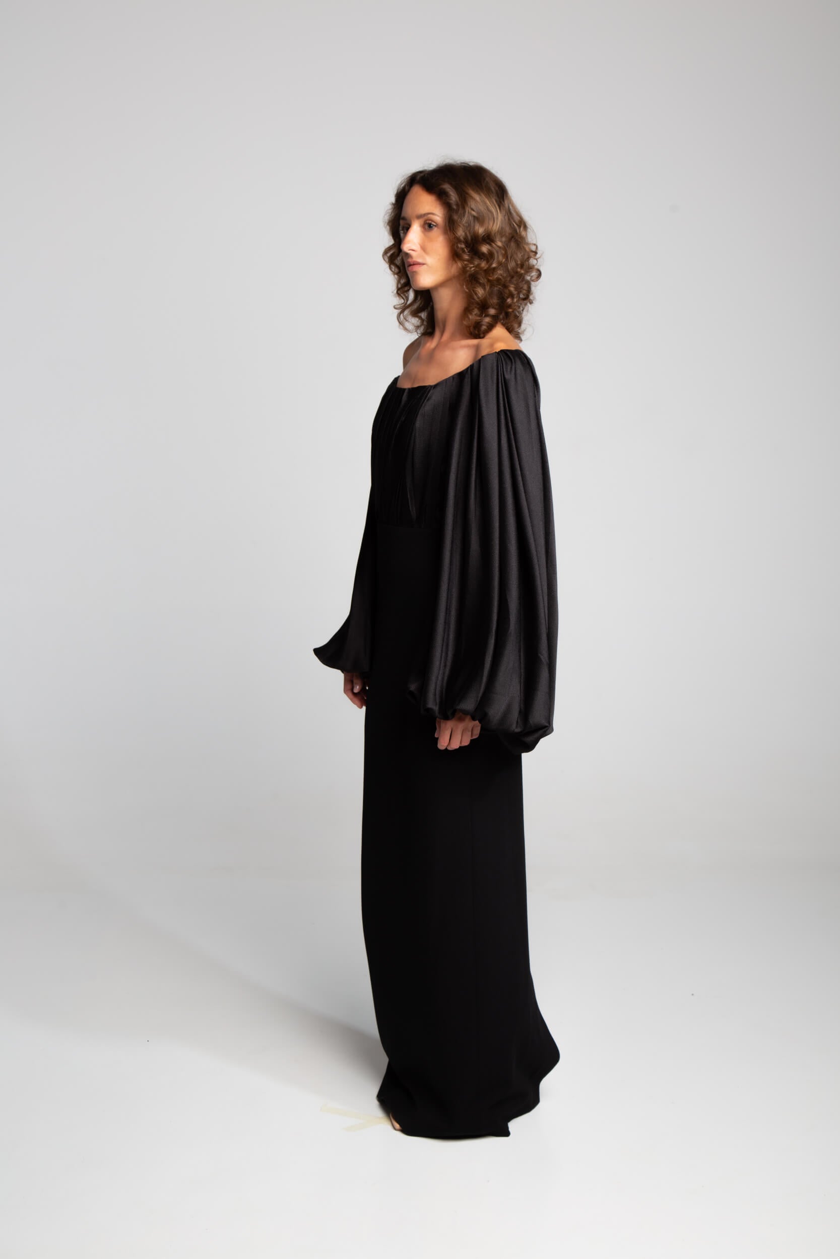 Off shoulder black gown with pleated bodice and sculptural balloon sleeves contemporary design