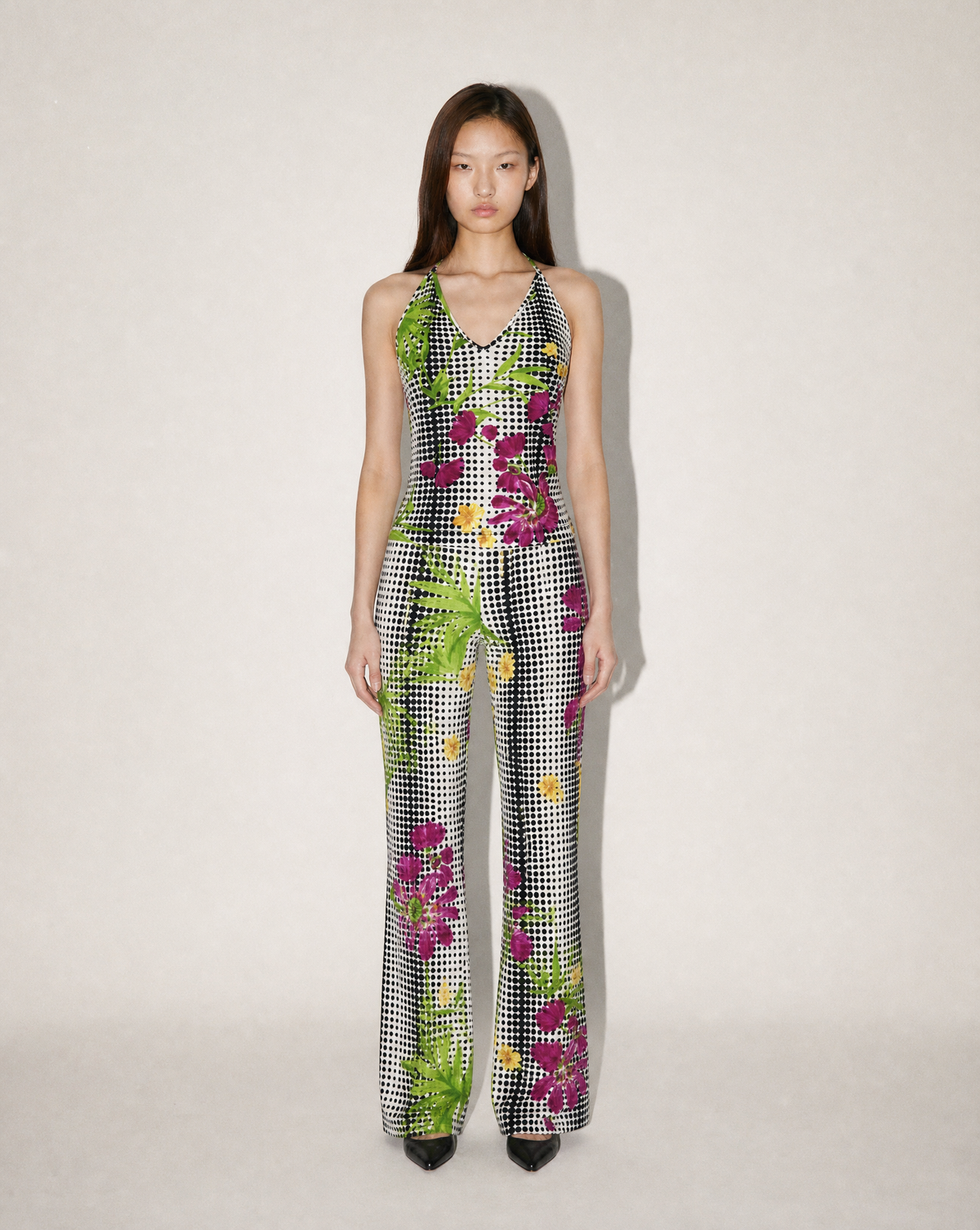 Shop this archival Gianni Versace Spring/Summer 1995 jumpsuit at Mezzanotte Vintage. The halter-neck, wide-leg design combines tropical flowers, palm leaves and black-and-white gingham.