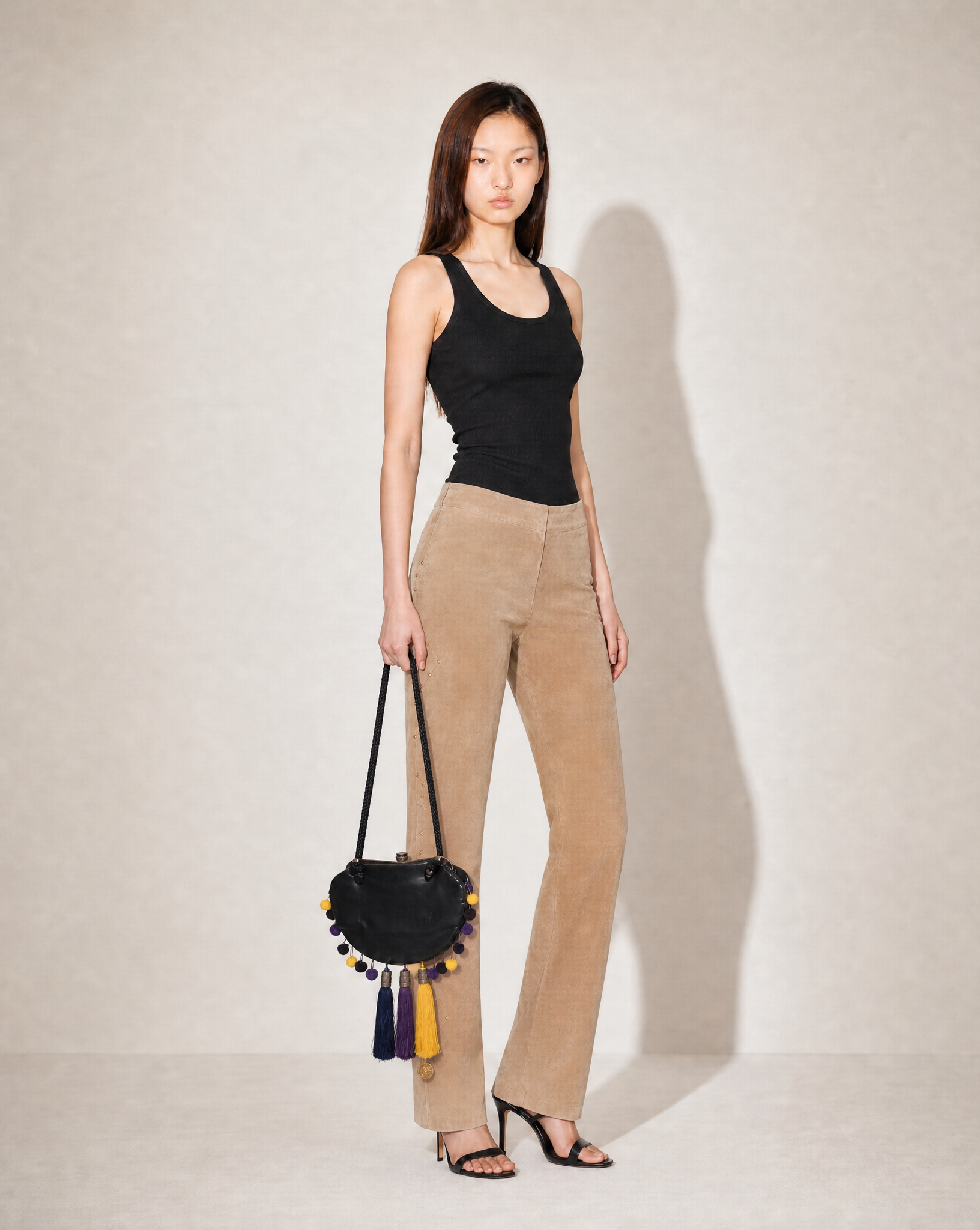 Iconic archival John Galliano 2007 bag with colorful tassels and pom-poms, available at Mezzanotte Madrid.
