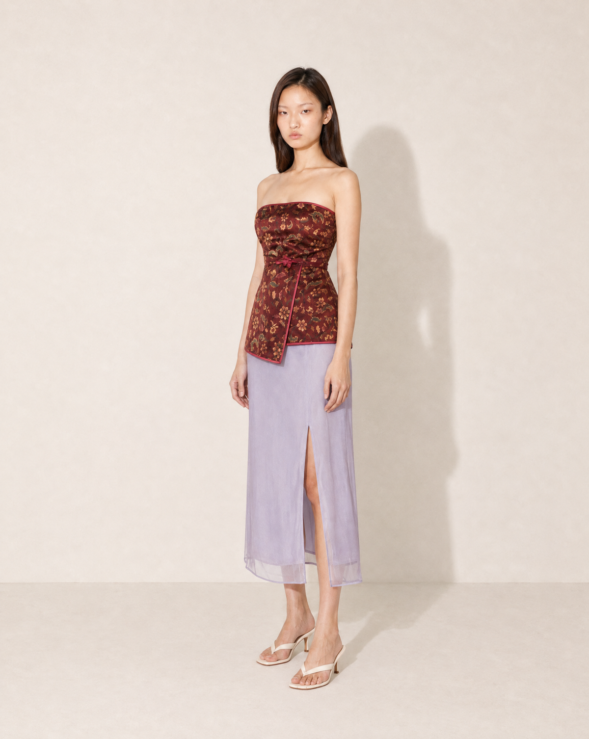 Shop this archival Kenzo Jungle top at Mezzanotte archival. Designed during Kenzo Takada’s era, it features a burgundy-red floral and paisley print, strapless shape and wrap-effect front.