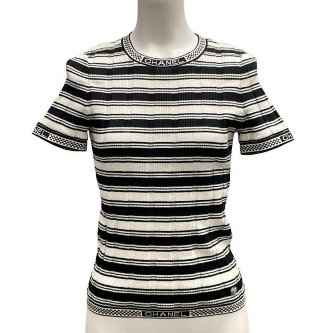 Close-up of the Chanel logo trim and ribbed knit construction on the black and white striped top.
