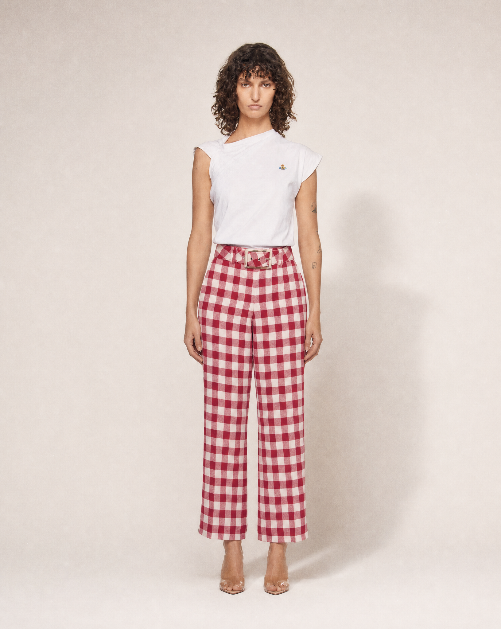 Vintage Moschino red and white gingham high-waisted cotton trousers with statement bow belt, available for purchase and luxury rental across Europe from Mezzanotte.
